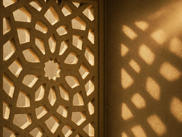 Carved geometric screen casting patterned light across a wall