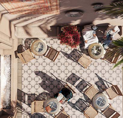 Outdoor terrace seen from above with woven chairs and people seated at tables